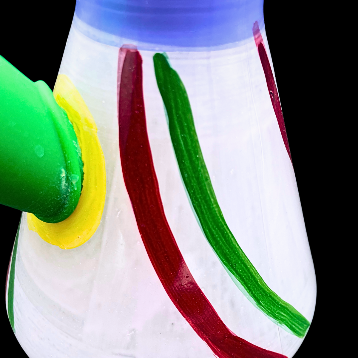 Close-up of the Rasta Rascal bong’s striped glass base and green bowl connection